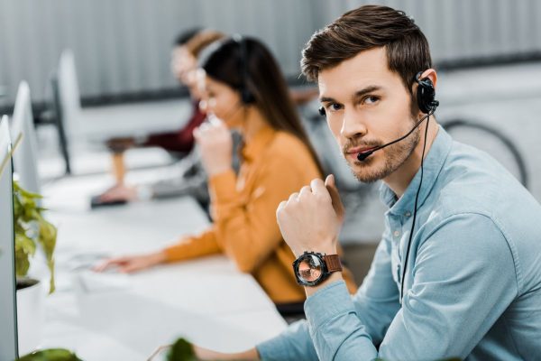 selective focus of call center operator in headset in office